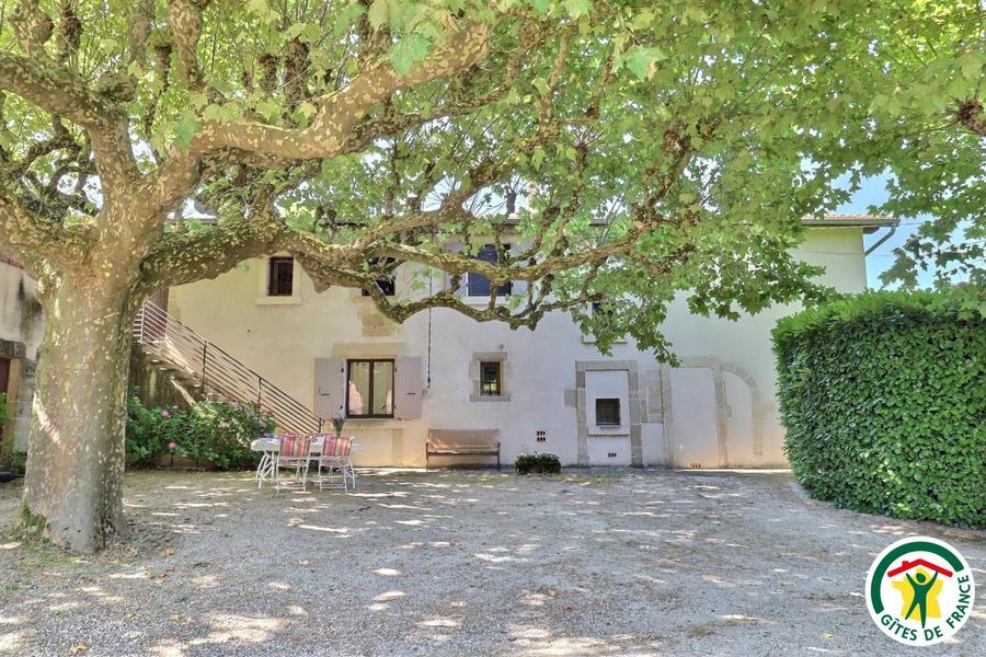 Le gîte et son salon de jardin privatif dans la cour sous les platanes