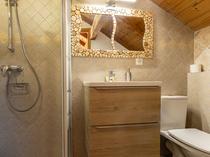 Salle de bains lumineuse carrelée, bac à douche, évier, ameublement bois