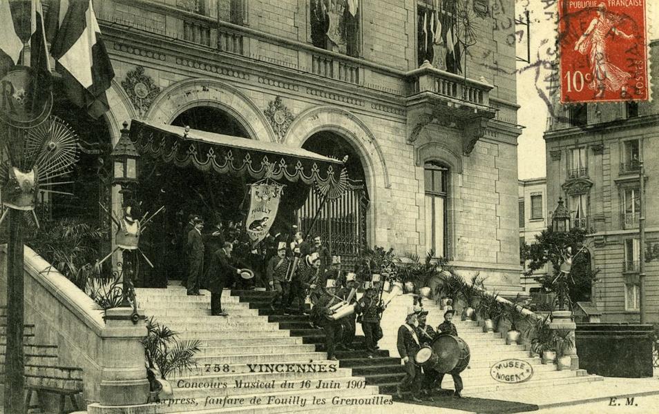 Carte postale de la fanfare de Fouilly-la-Grenouille, tirée d'un film Pathé, devant l'hôtel de ville de Vincennes 