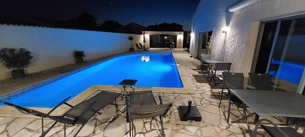 La terrasse et la cuisine, éclairées de nuit.