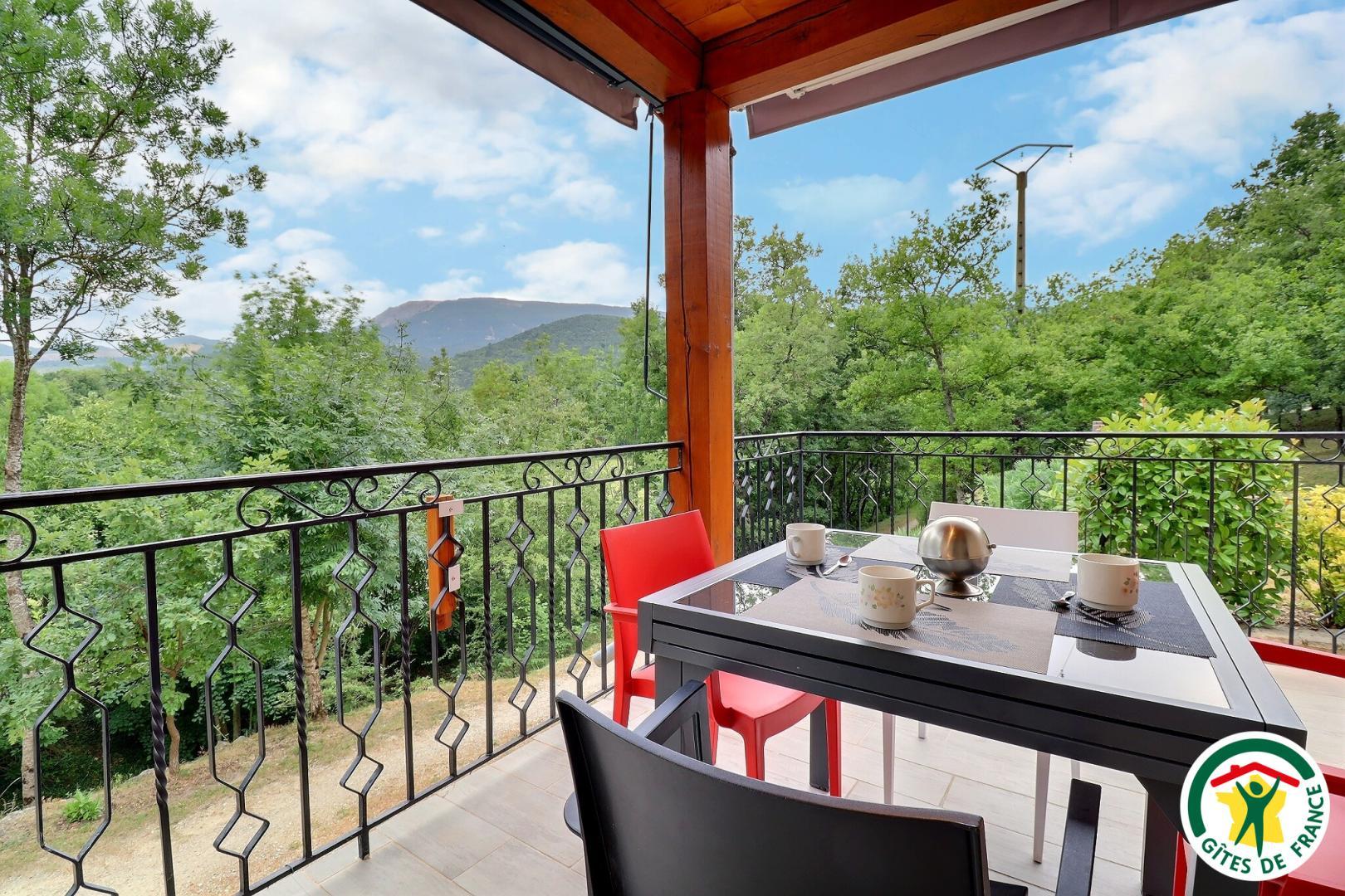 Terrasse abritée avec salon de jardin, vue sur les montagnes et les chênes verts