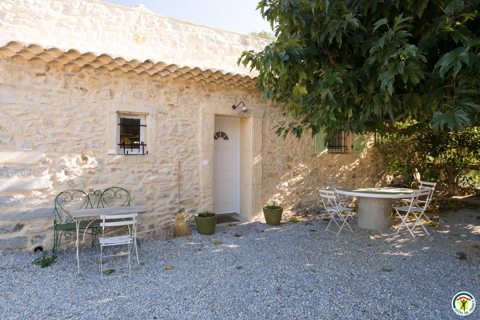 Entrée principale du gîte avec coin table sous murier