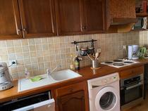 Cuisine d'appartement avec plaques électriques, ameublement bois et carrelage