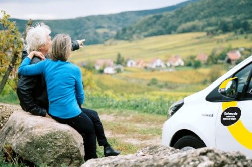 Un couple à la campagne devant une Yelomobile