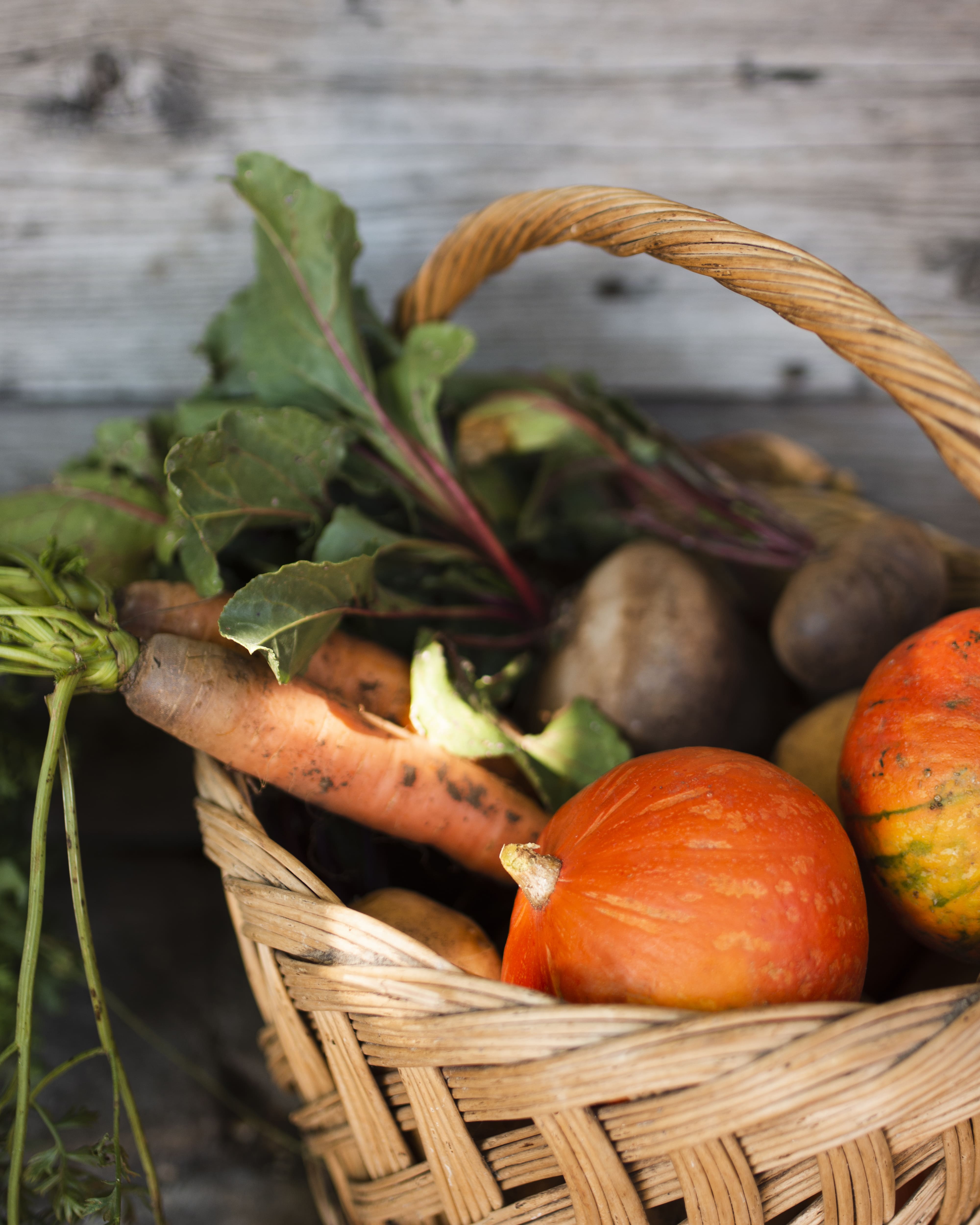 Panier en osier avec des légumes : carottes, potimarrons, betteraves...