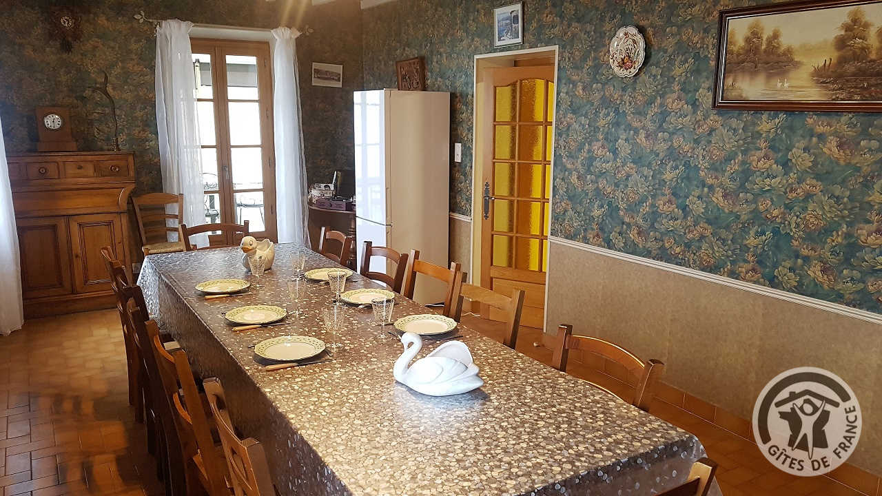 Grand gîte 'Au Pied du Pottu' à Brullioles (Rhône, Ouest Lyonnais, Mont du Lyonnais) : la Salle à manger (au 1er étage) ouvrant sur la véranda et aussi sur la cuisine.