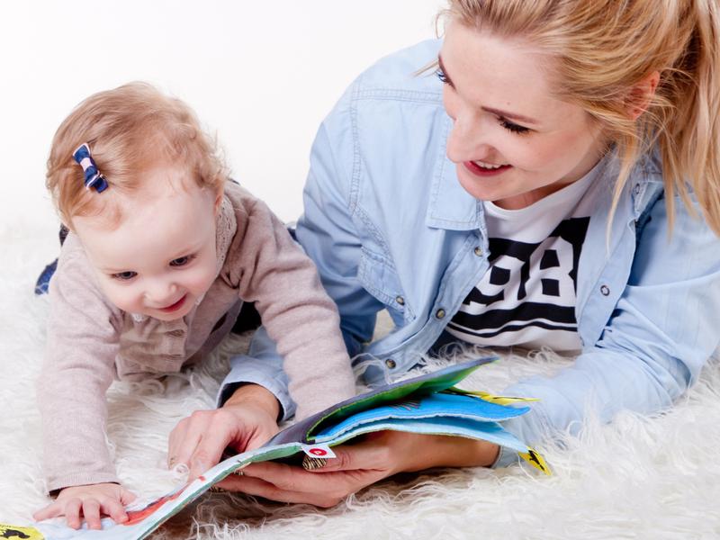 Une maman et son bébé regarde un livre