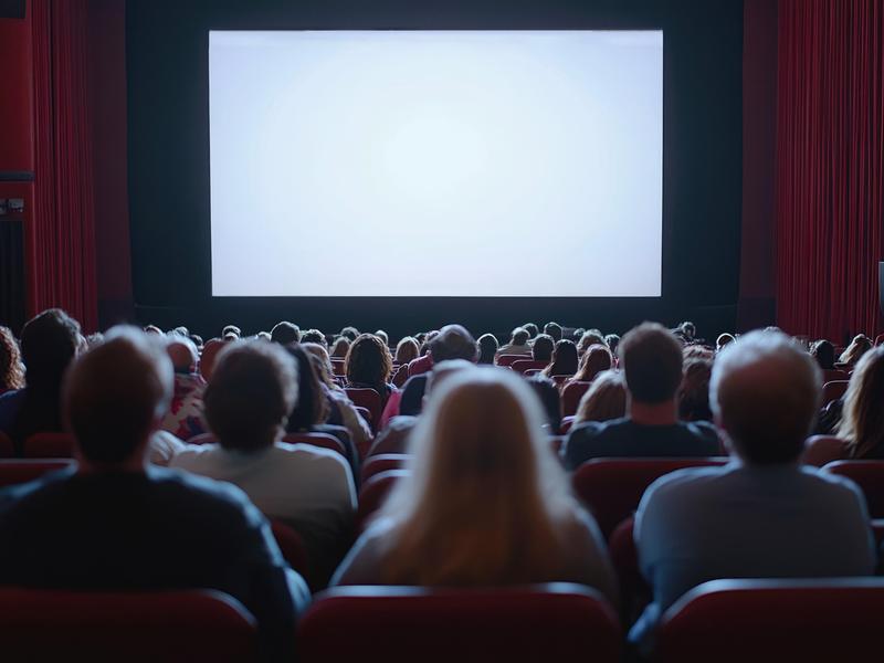 Des gens assis au cinéma attendent leur film