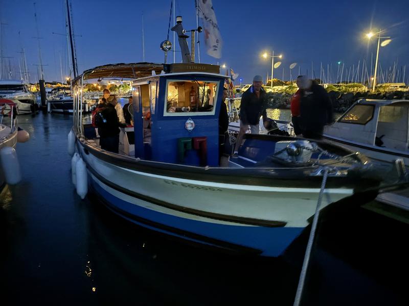 Un bateau amaré au port, de nuit.