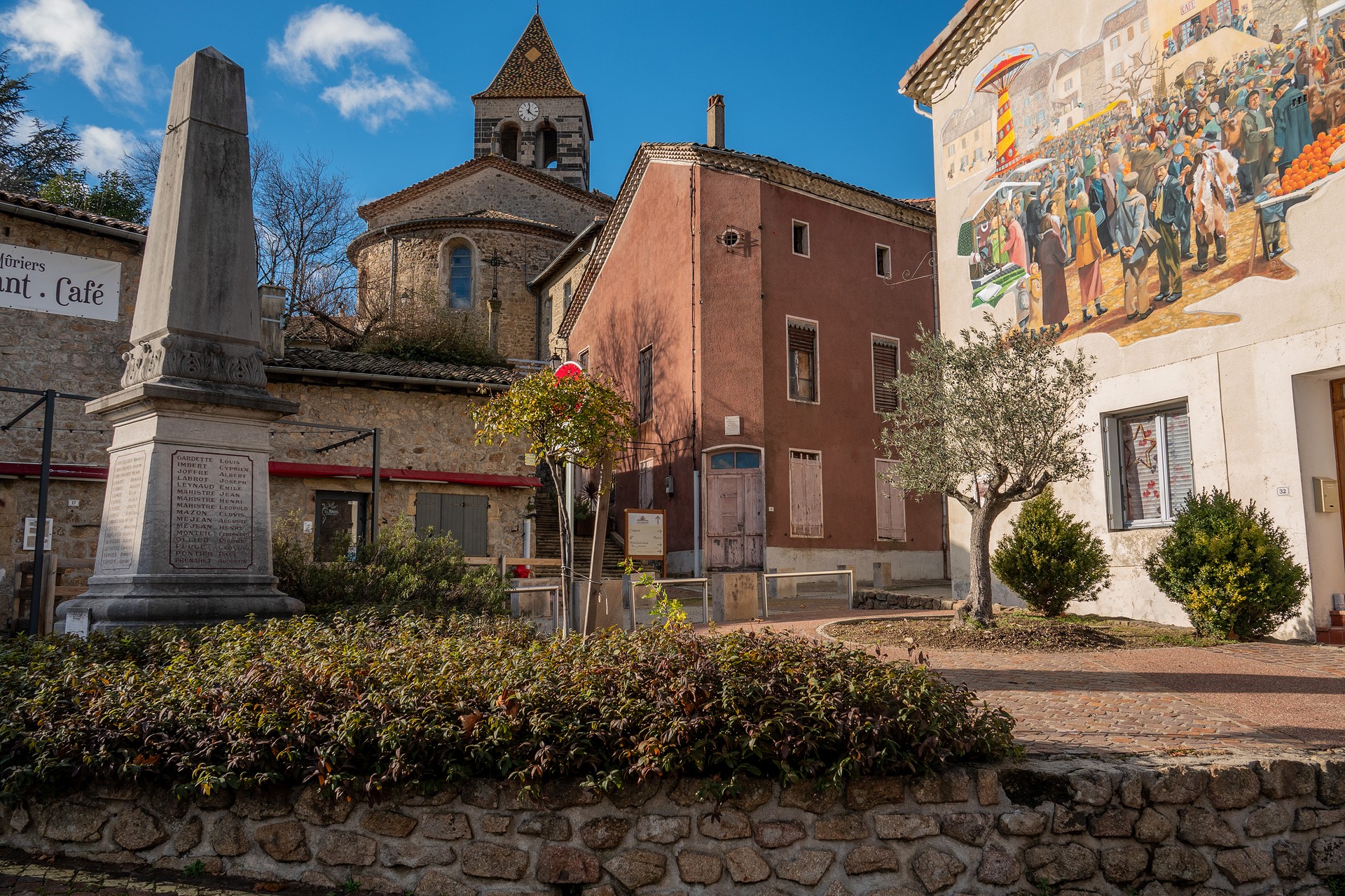 Meyras - Vue sur la fresque de la St Blaise et l'église Saint Etienne ©sourcesetvolcans