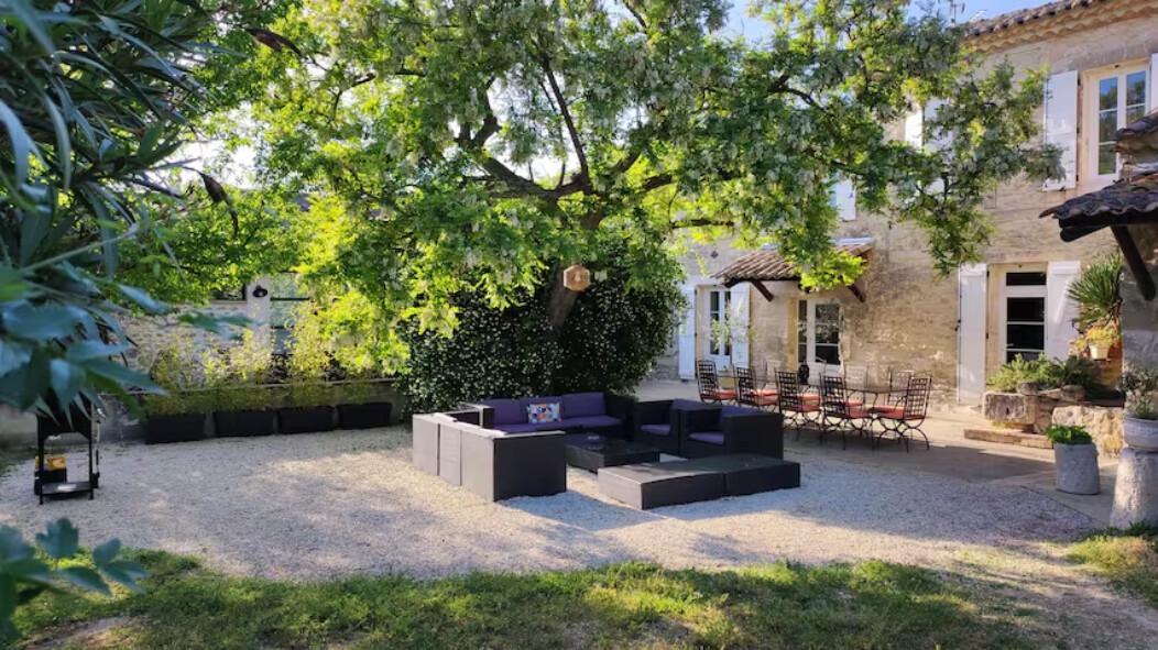 Le Mas à l'ombre de l'accacia avec son salon de jardin et la table pour les repas.