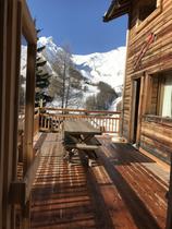 Terrasse en bois avec vue sur les montagnes enneigées