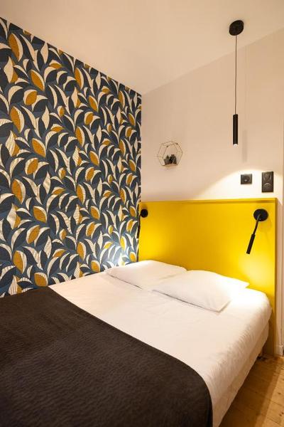 Une chambre bleue et jaune avec un lit double.