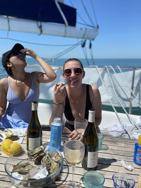 Deux dames mangeant des huitres sur le bateau.