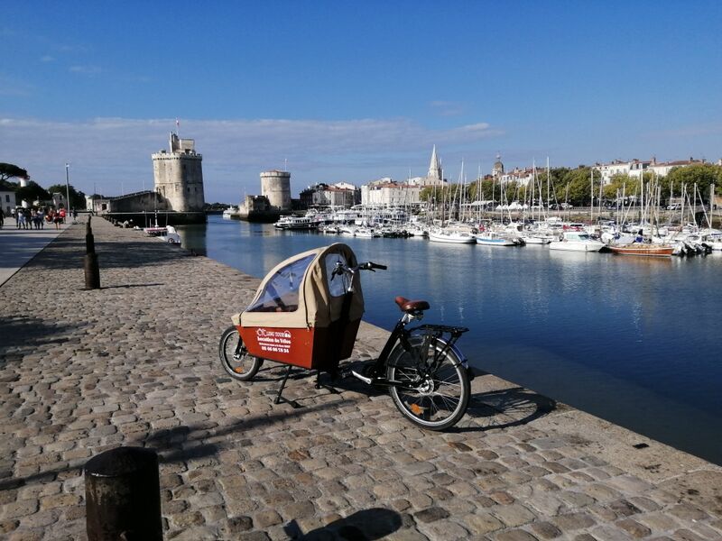 un vélo cargo avec la partie avant couverte, devant le Vieux-Port