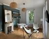 Coin salon Salon avec fauteuils, table ronde et fausse cheminée Ⓒ Villa Marie Céline