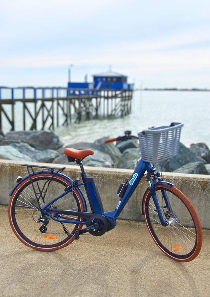 Un vélo bleu devant un carrelet bleu.
