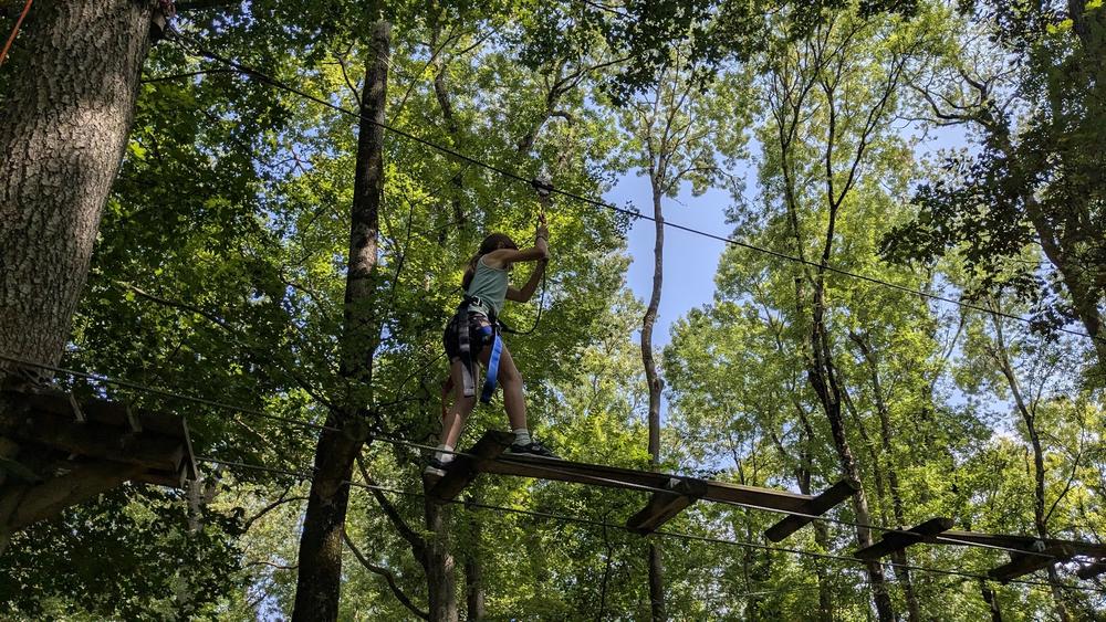 Jeune fille sur le parcours d'accrobranche