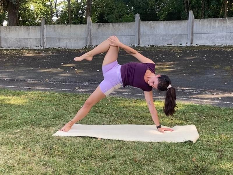 personne pratiquant le yoga sur un tapis en extérieur