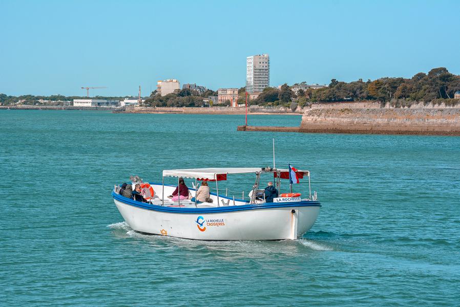 La chaloupe avec quelques personnes à bord s'en allant en mer.