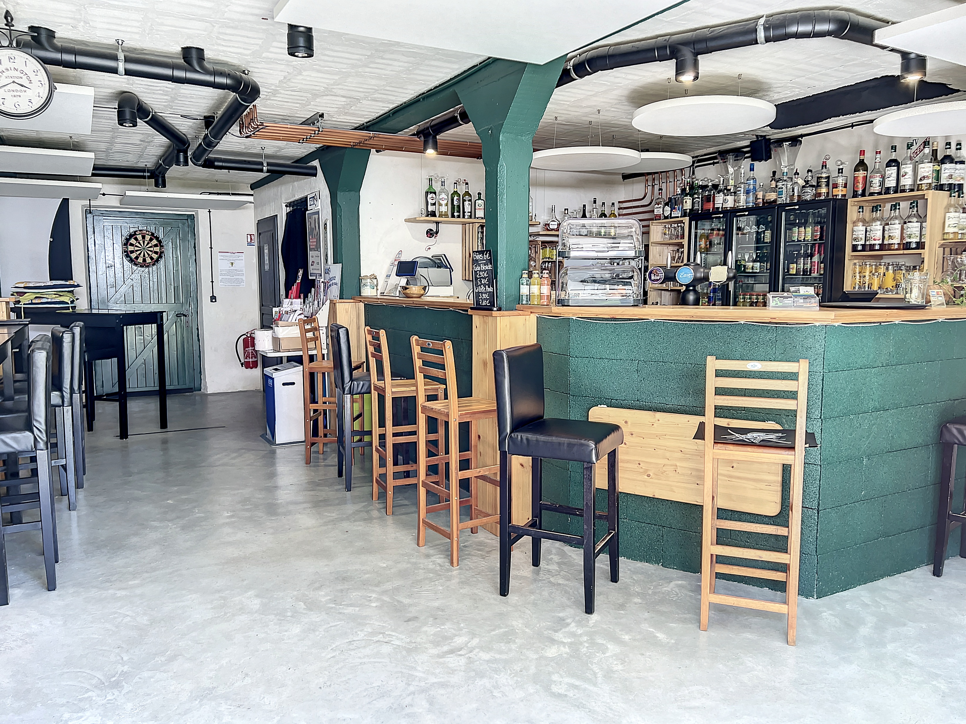 bar en bois orné de bouteilles et tabourets, ambiance chaleureuse