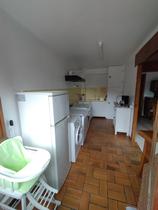 Coin cuisine en couloir avec machine à laver, gazinière, évier