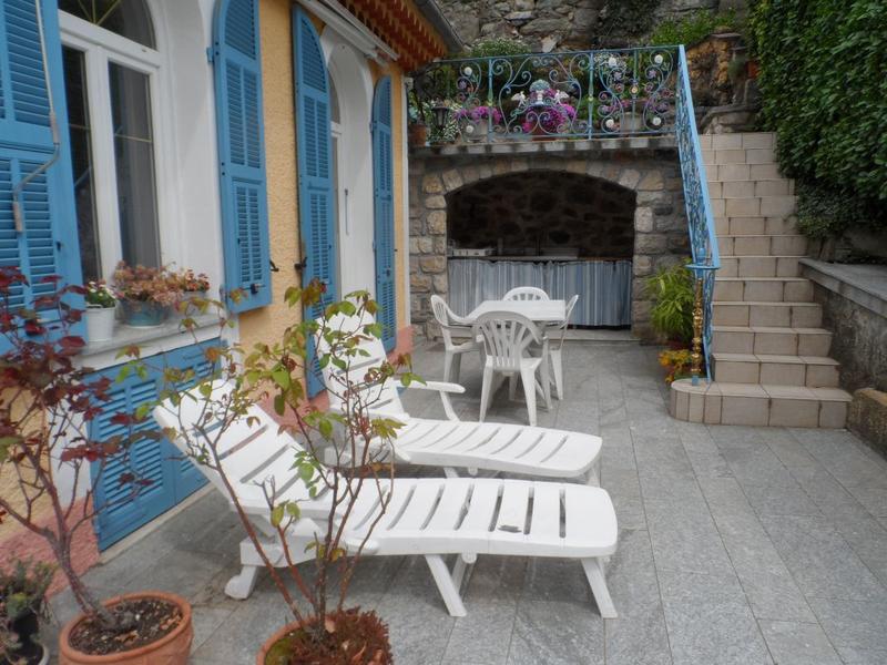 La terrasse privée avec la cuisine d'été au fond, l'accès au jardinet avec chaises longues