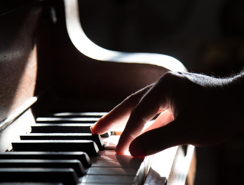 Main jouant sur un piano