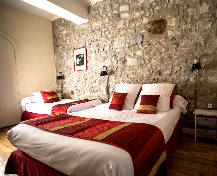 Une chambre triple avec un lit double et un lit simple.
