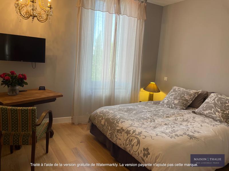 une chambre avec lit double et télévision.