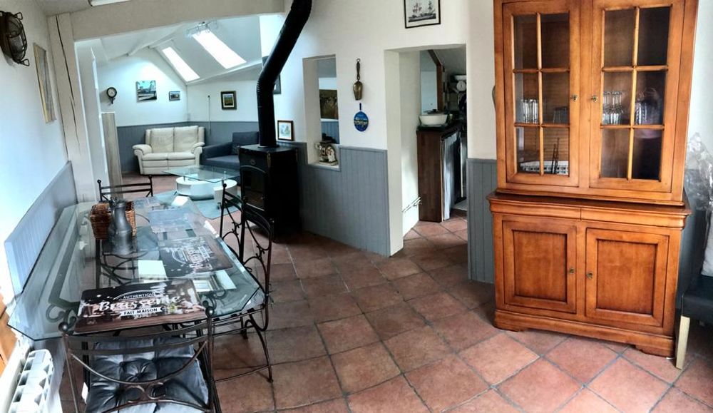 Vue grand angle du salon avec poële, bureau et vaisselier