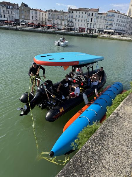 Le zodiac dans le port de la Rochelle, une bouée tractée banane sur le côté, un paddle géant sur le toit.