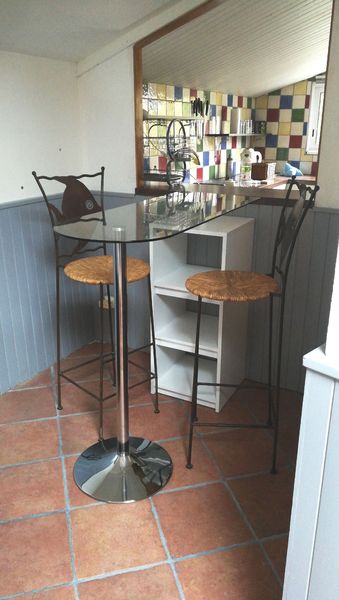 Espace bar avec table haute transparente et deux mange-debouts
