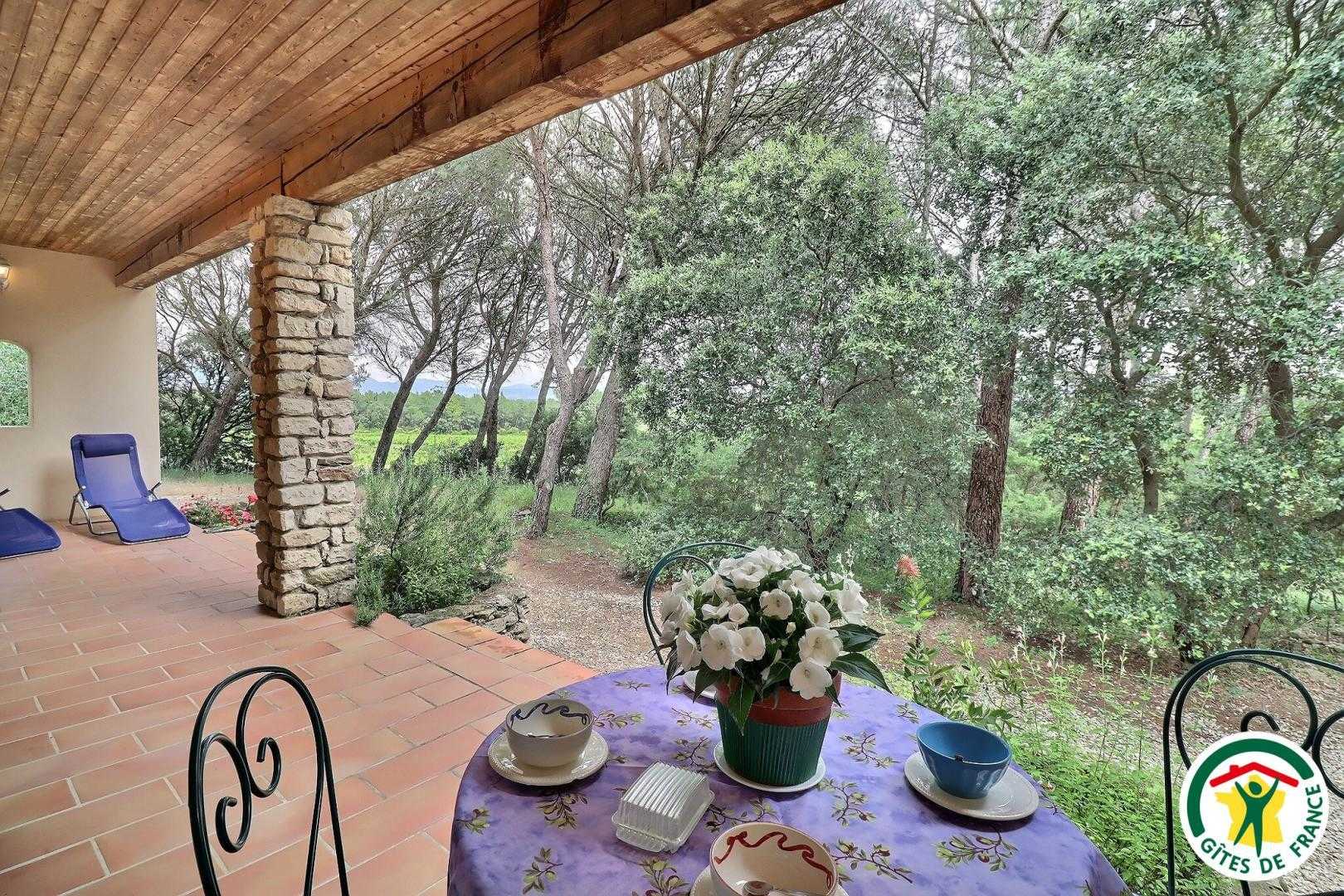 Terrasse du gîte, abritée avec salon de jardin et bains de soleil