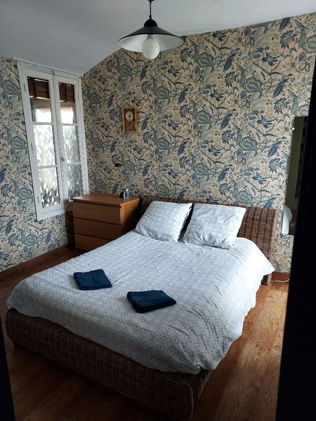 Chambre 1 avec lit double, fenêtre et papier peint fleuri