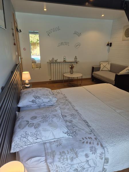 Une chambre avec lit double, on voit la piscine dans le reflet d'un miroir.