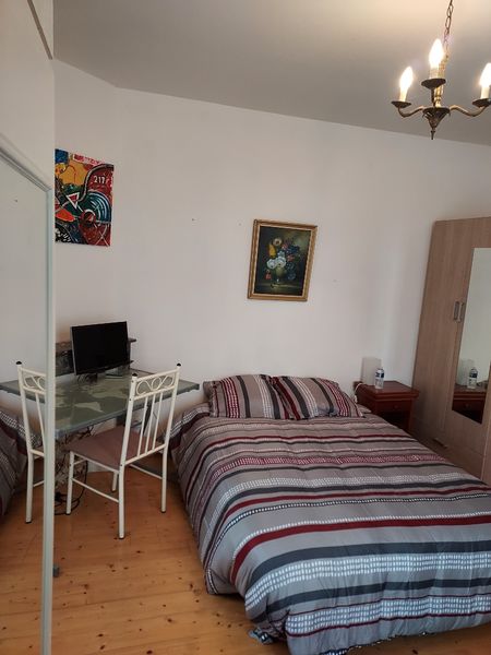 Chambre 2 avec lit double, armoire avec miroir et bureau avec écran