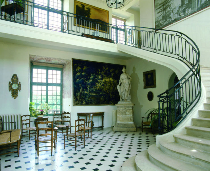 18th century vestibule with a grand staircase, its paintings and tapestries