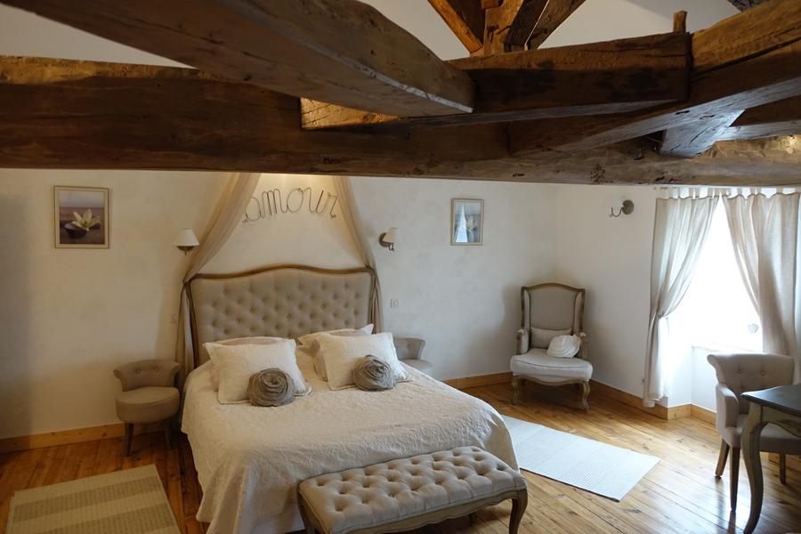 Chambre avec déco romantique et poutres apparentes