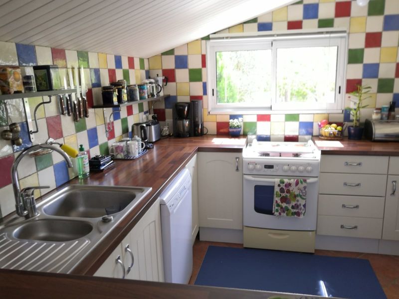 Cuisine tout équipée avec faïence colorée sur les murs