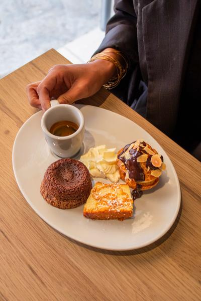 Un café gourmand avec un expresso, trois mini desserts et de la chantilly.