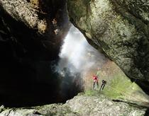 homme en rappel arc en ciel et cascade