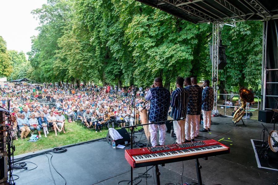 scène avec des musiciens en face du public assis sur des chaises