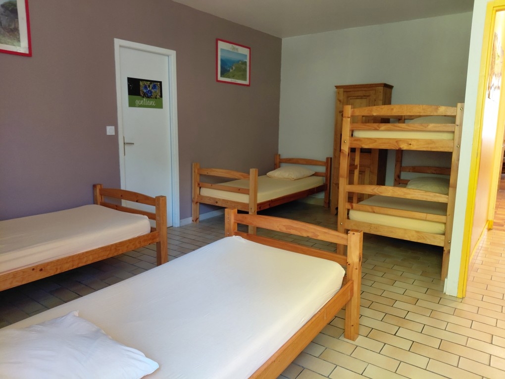 Dortoir de cinq couchages dans une grande chambre ouverte.