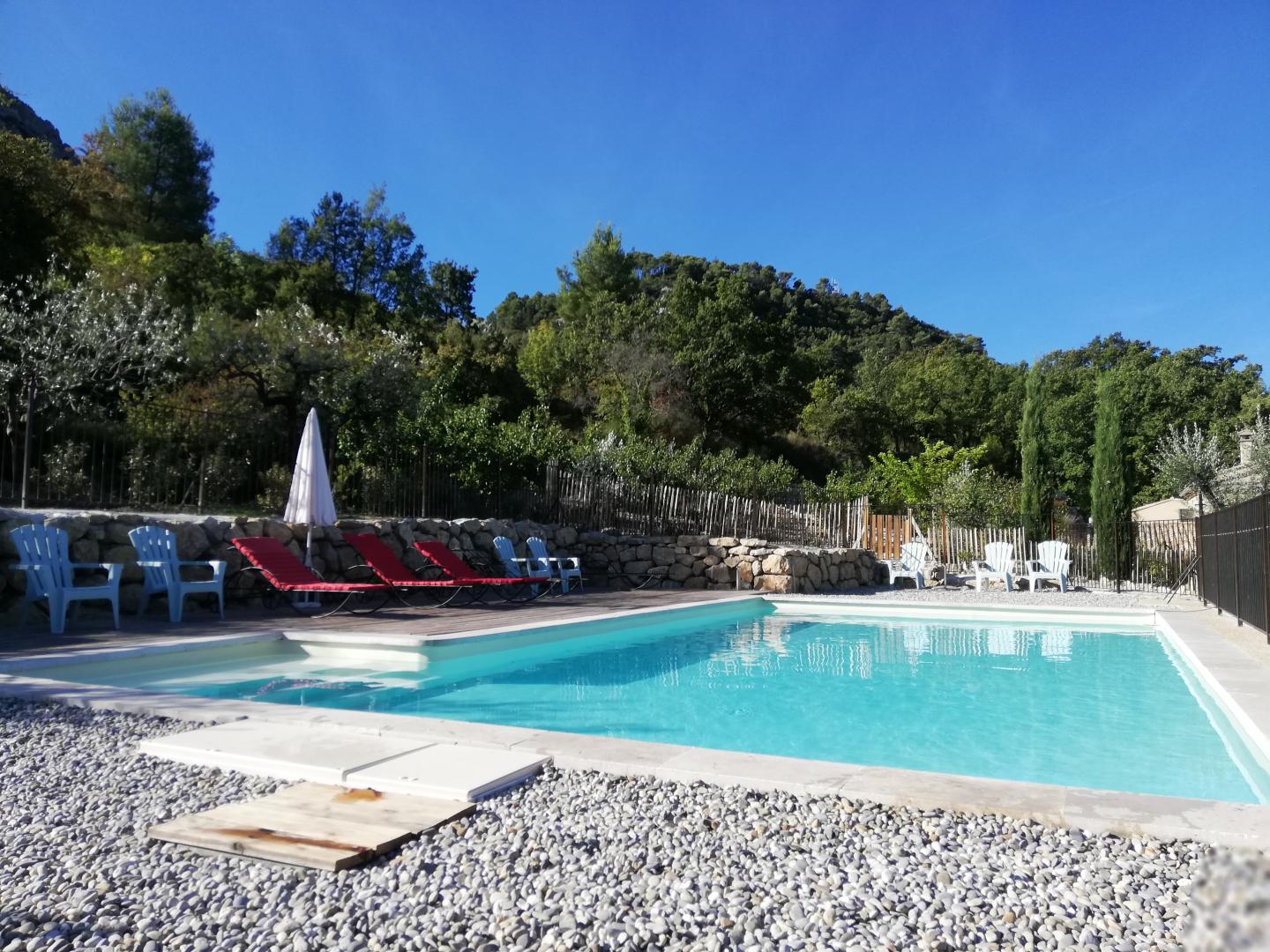 La piscine surplombe le terrain à l'écart des gîtes.