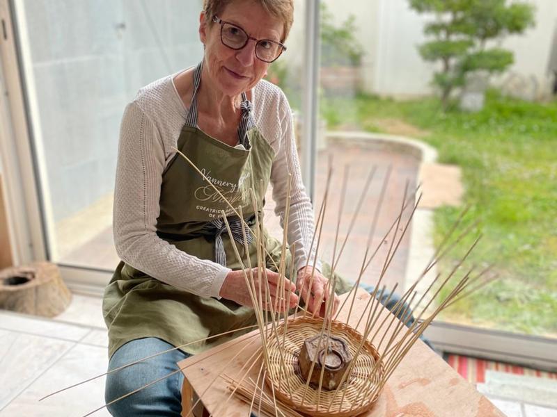 Personne tressant un panier en osier