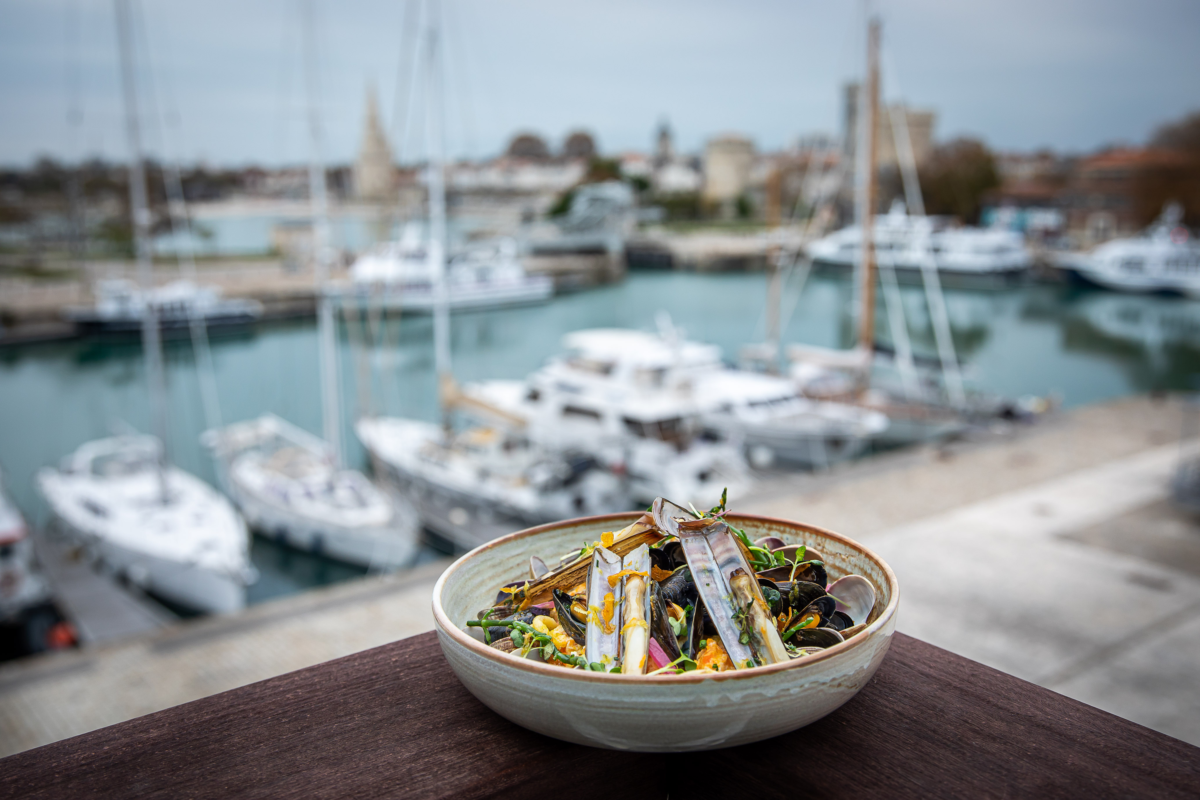 Une assiette de couteaux, en fond le bassin des chalutiers.