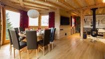 Espace salle à manger avec sa grande table ovale, très lumineuse, salon en arrière plan