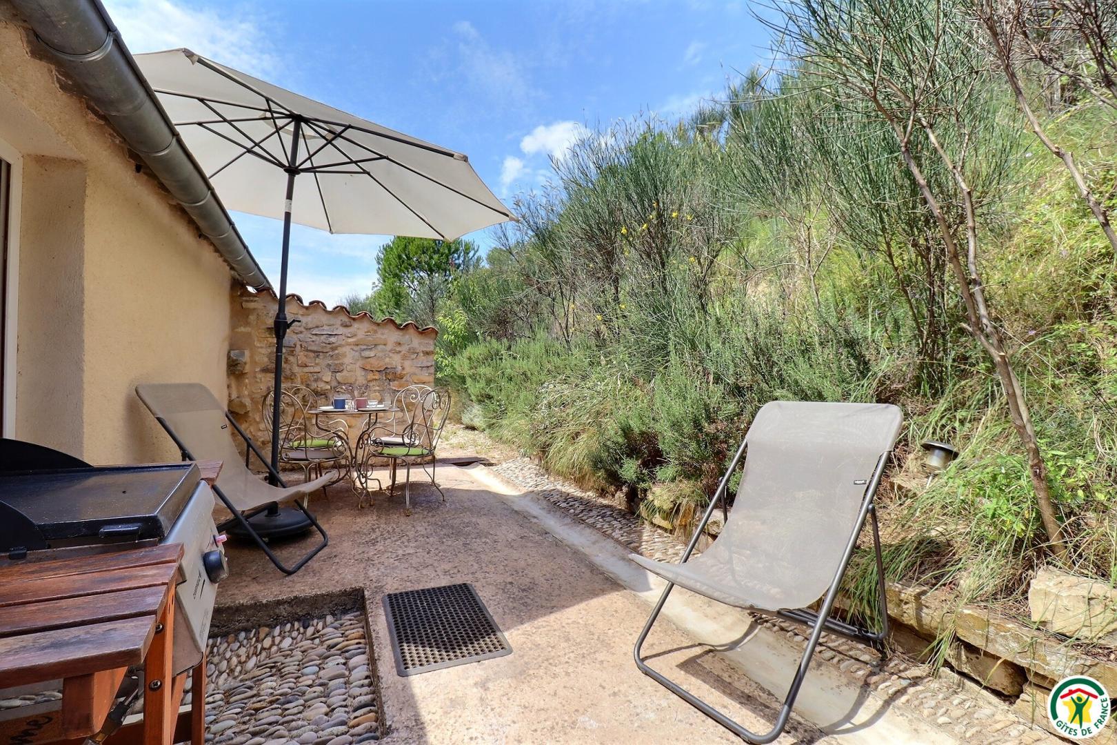 Terrasse privative avec salon de jardin, transats et plancha gaz