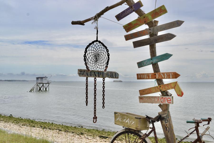 Une scultpure colorée en bois devant l'océan, sur l'ile d'Aix.